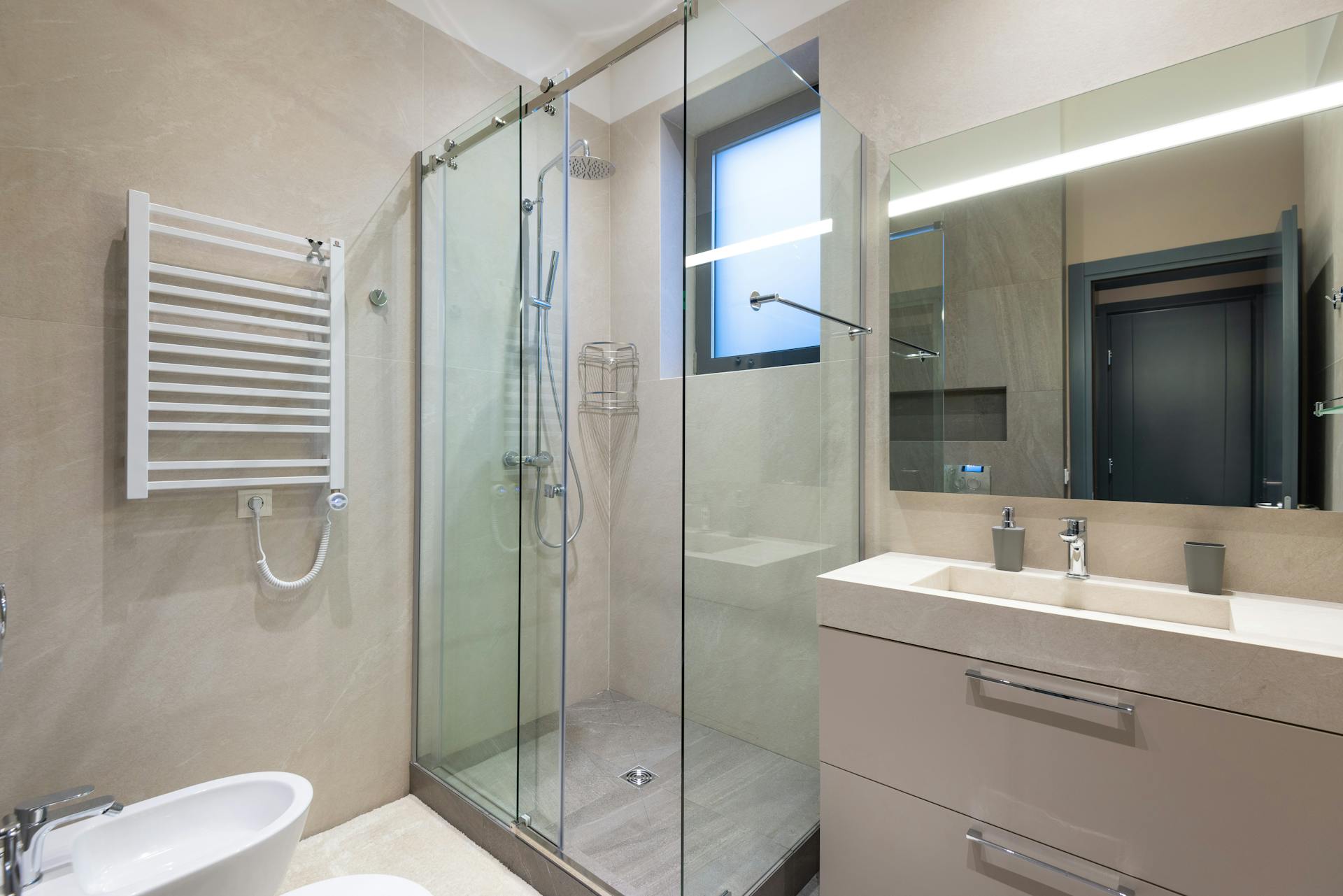 Calm modern bathroom with a glass shower — Sydney Sealed leak repair FAQs